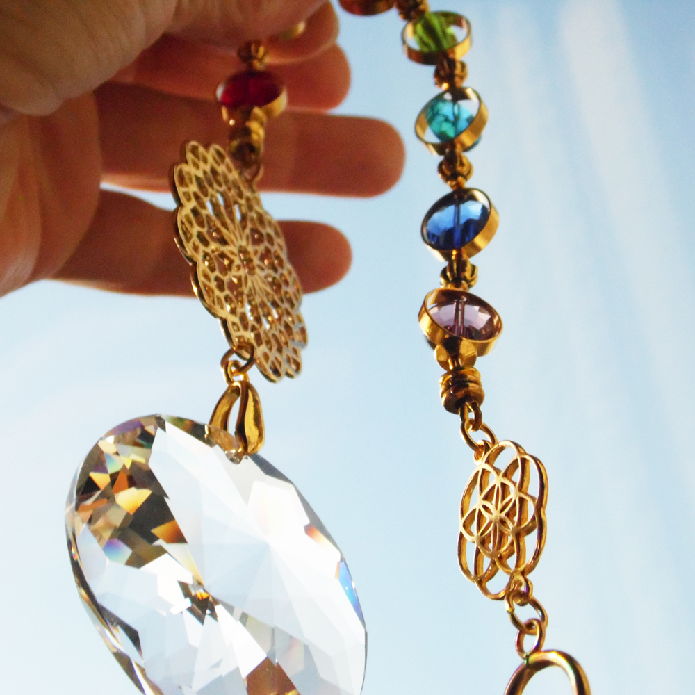 goldener sonnenfänger mit sieben chakra farben kristall